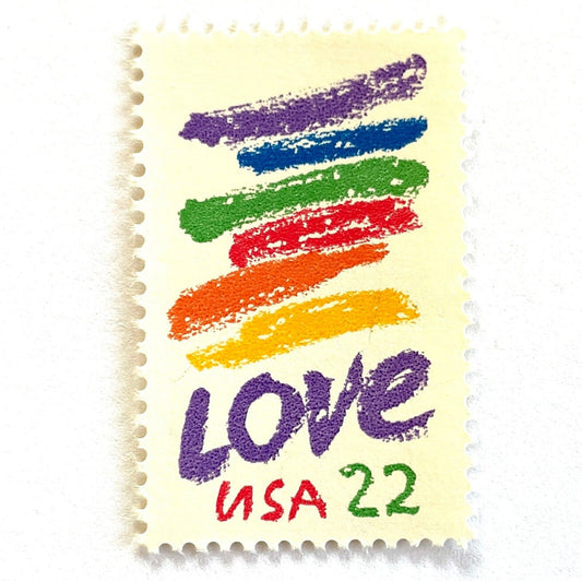 Love Crayon postage stamp from 1985 featuring colorful brush strokes and bold purple LOVE lettering on vintage unused 22-cent USPS postage, Scott 2143.