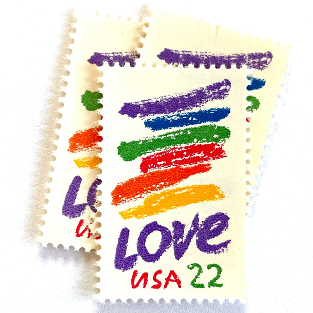 Love Crayon postage stamps from 1985 featuring colorful brush strokes and bold purple LOVE lettering on vintage unused 22-cent USPS postage, Scott 2143.
