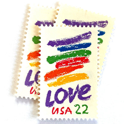 Love Crayon postage stamps from 1985 featuring colorful brush strokes and bold purple LOVE lettering on vintage unused 22-cent USPS postage, Scott 2143.