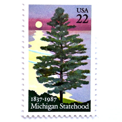 Image of Michigan Statehood postage stamps from 1987, featuring a white pine tree before a sunrise over Lake Huron on vintage unused 22-cent USPS postage, Scott 2246.