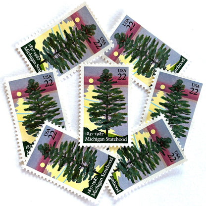 Image of Michigan Statehood postage stamps from 1987, featuring a white pine tree before a sunrise over Lake Huron on vintage unused 22-cent USPS postage, Scott 2246.