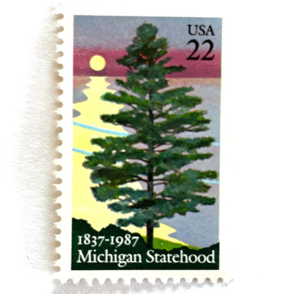 Image of Michigan Statehood postage stamps from 1987, featuring a white pine tree before a sunrise over Lake Huron on vintage unused 22-cent USPS postage, Scott 2246.