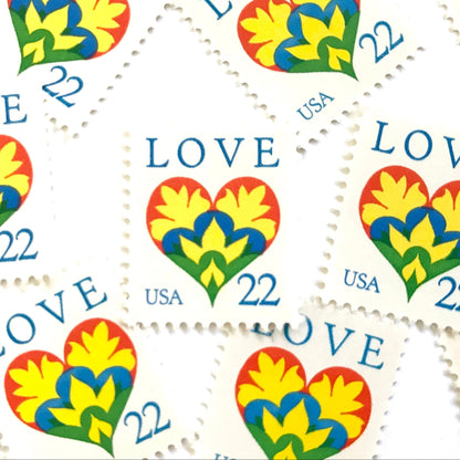 Hearts & Flowers postage stamps from 1987 featuring a colorful folk art heart surrounded by flowers on vintage unused 22-cent USPS postage, Scott 2248.