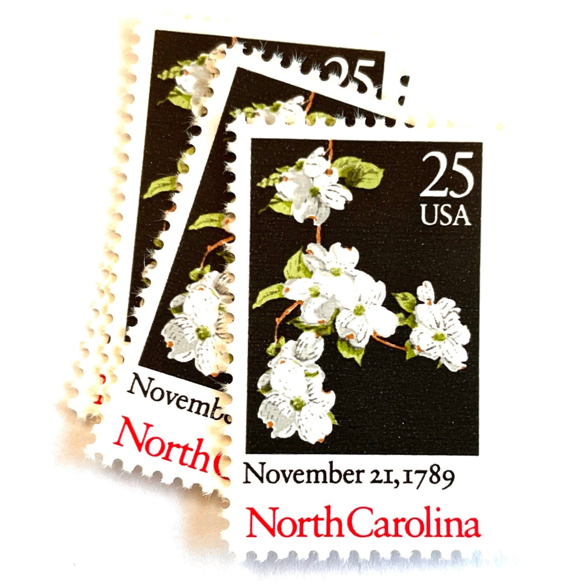 Image of North Carolina Statehood postage stamps from the 1989 Bicentenary Statehood series, featuring white dogwood flowers on a black background on vintage unused 25-cent USPS postage, Scott 2347.