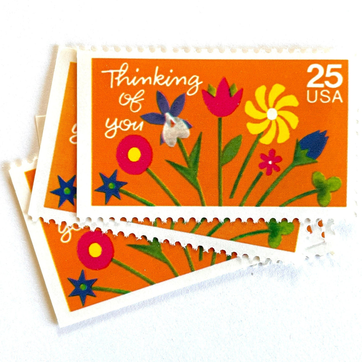 Thinking of You postage stamps from 1988 featuring colorful folk art flowers against a sunny orange background on vintage unused 25-cent USPS postage, Scott 2397.