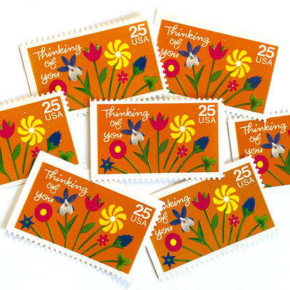 Thinking of You postage stamps from 1988 featuring colorful folk art flowers against a sunny orange background on vintage unused 25-cent USPS postage, Scott 2397.