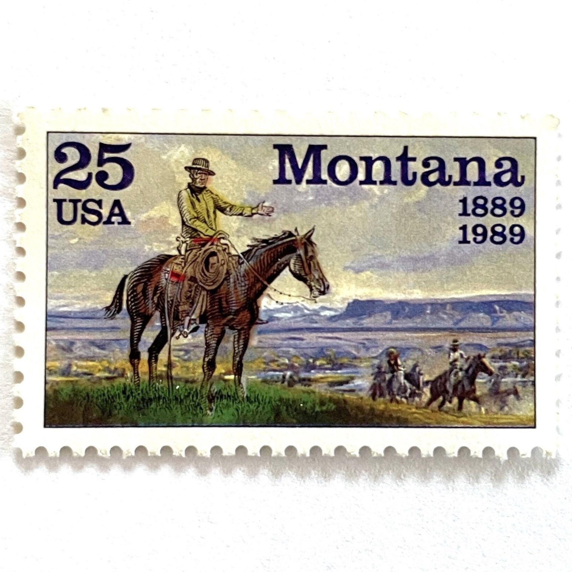 Image of Montana Statehood postage stamps from 1989, featuring C.M. Russell Western art with a cowboy on horseback and riders on vintage unused 25-cent USPS postage, Scott 2401.