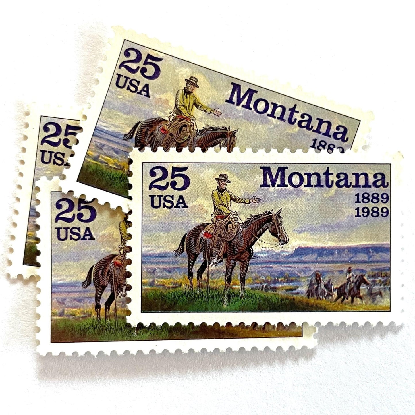 Image of Montana Statehood postage stamps from 1989, featuring C.M. Russell Western art with a cowboy on horseback and riders on vintage unused 25-cent USPS postage, Scott 2401.