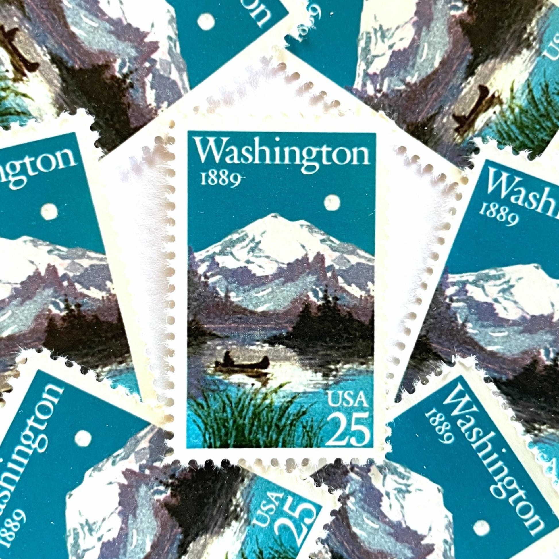 Image of Washington Statehood postage stamps from 1989, featuring Mount Rainier above a quiet lake with a canoe on vintage unused 25-cent USPS postage, Scott 2404.