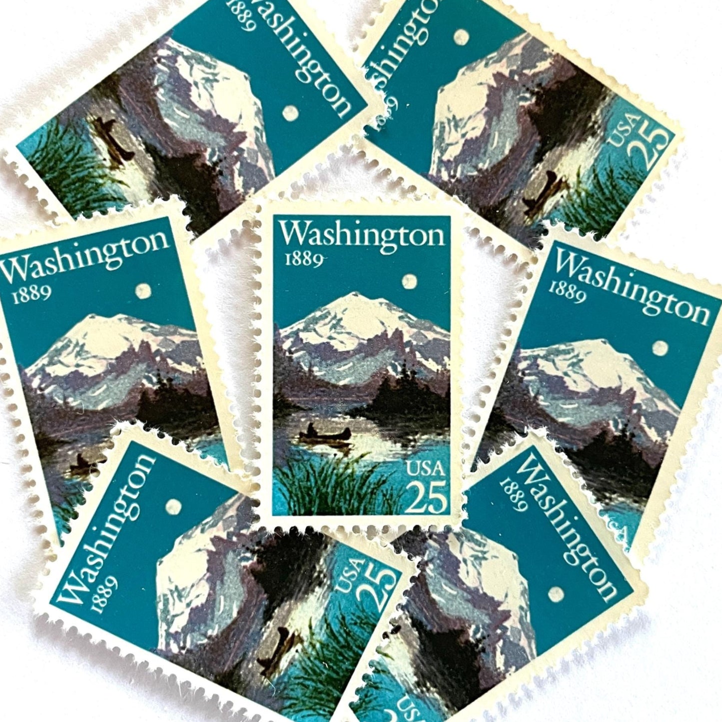 Image of Washington Statehood postage stamps from 1989, featuring Mount Rainier above a quiet lake with a canoe on vintage unused 25-cent USPS postage, Scott 2404.