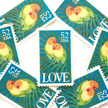 Love Birds postage stamps from 1991 featuring two colorful Fischer’s lovebirds cuddling on a palm frond on vintage unused 52-cent USPS postage, Scott 2537.