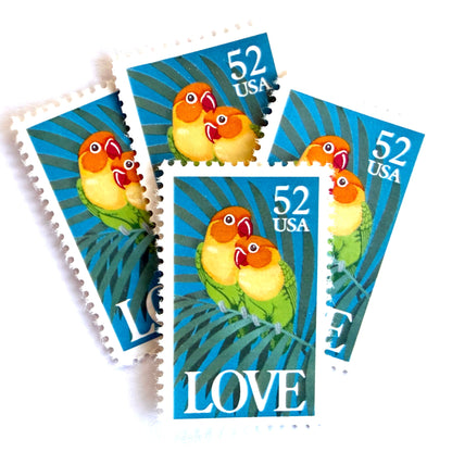 Love Birds postage stamps from 1991 featuring two colorful Fischer’s lovebirds cuddling on a palm frond on vintage unused 52-cent USPS postage, Scott 2537.