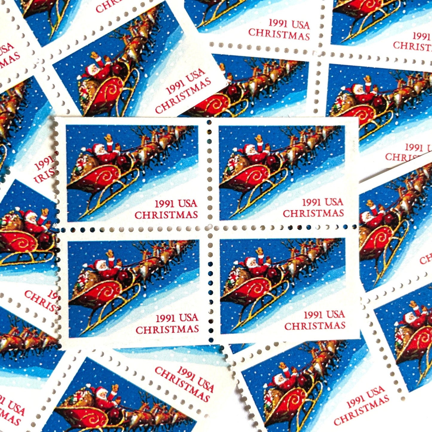 Image of 1991 Contemporary Christmas Series “Santa and Sleigh” 29-cent mail stamps. Scott #2585. Stamp Themes: Santa Claus, Santa’s Sleigh, Christmas, Holiday, Holidays, Winter, Night Sky, Snowing. Blue postage stamp.