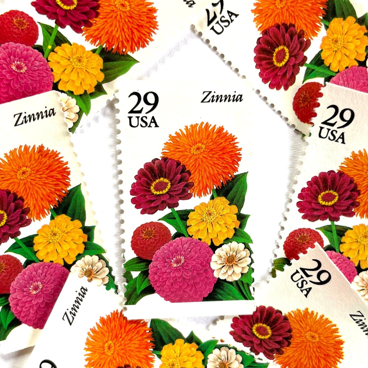 Image of Zinnia postage stamps from the 1994 Summer Garden Flowers series, featuring bright orange, pink, yellow, and cream zinnia blooms with green foliage on vintage unused 29-cent USPS postage, Scott 2830.