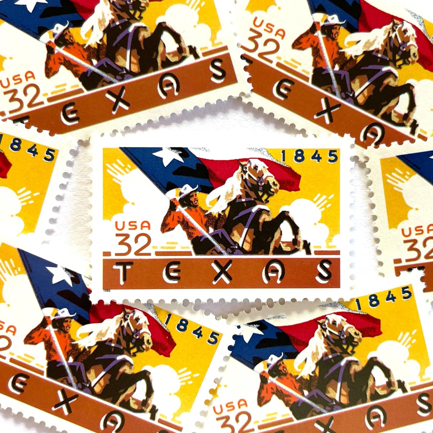 Image of Texas Statehood postage stamps from 1995, featuring a cowboy on horseback waving the Texas State flag on vintage unused 32-cent USPS postage, Scott 2968.