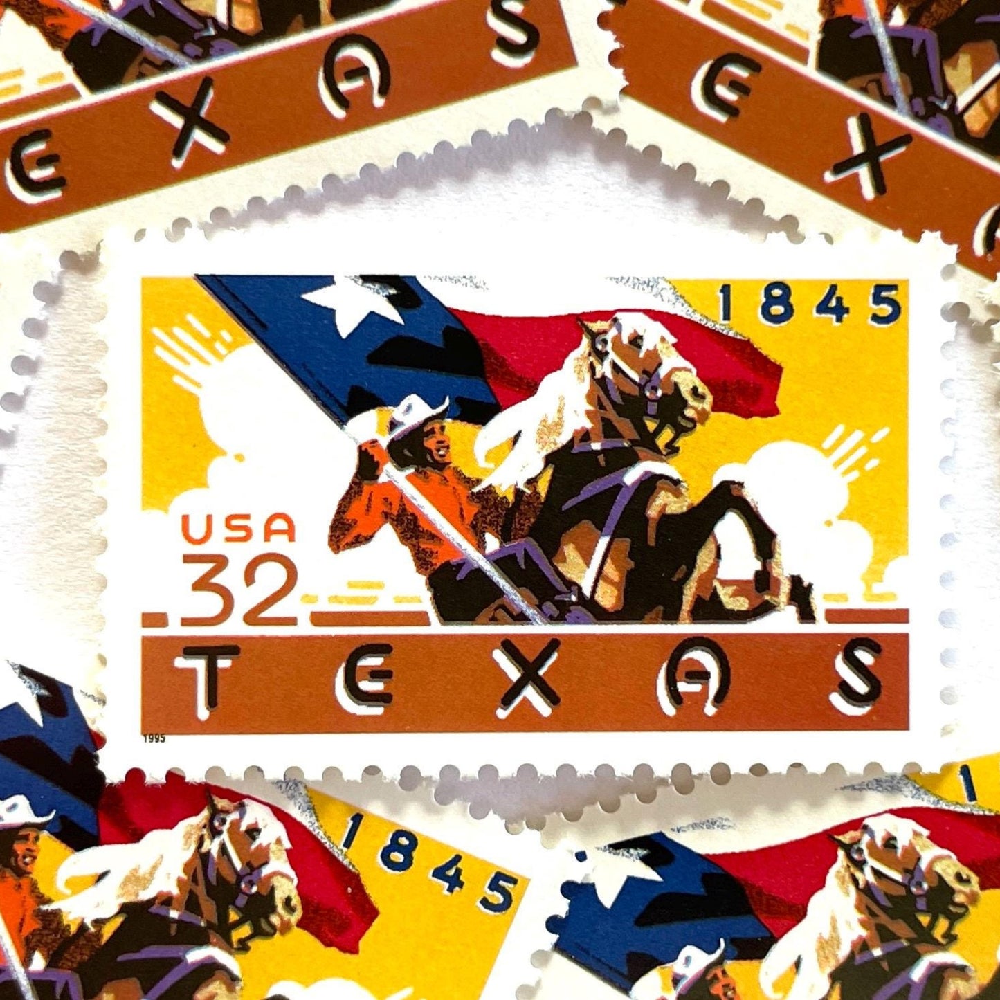 Image of Texas Statehood postage stamps from 1995, featuring a cowboy on horseback waving the Texas State flag on vintage unused 32-cent USPS postage, Scott 2968.