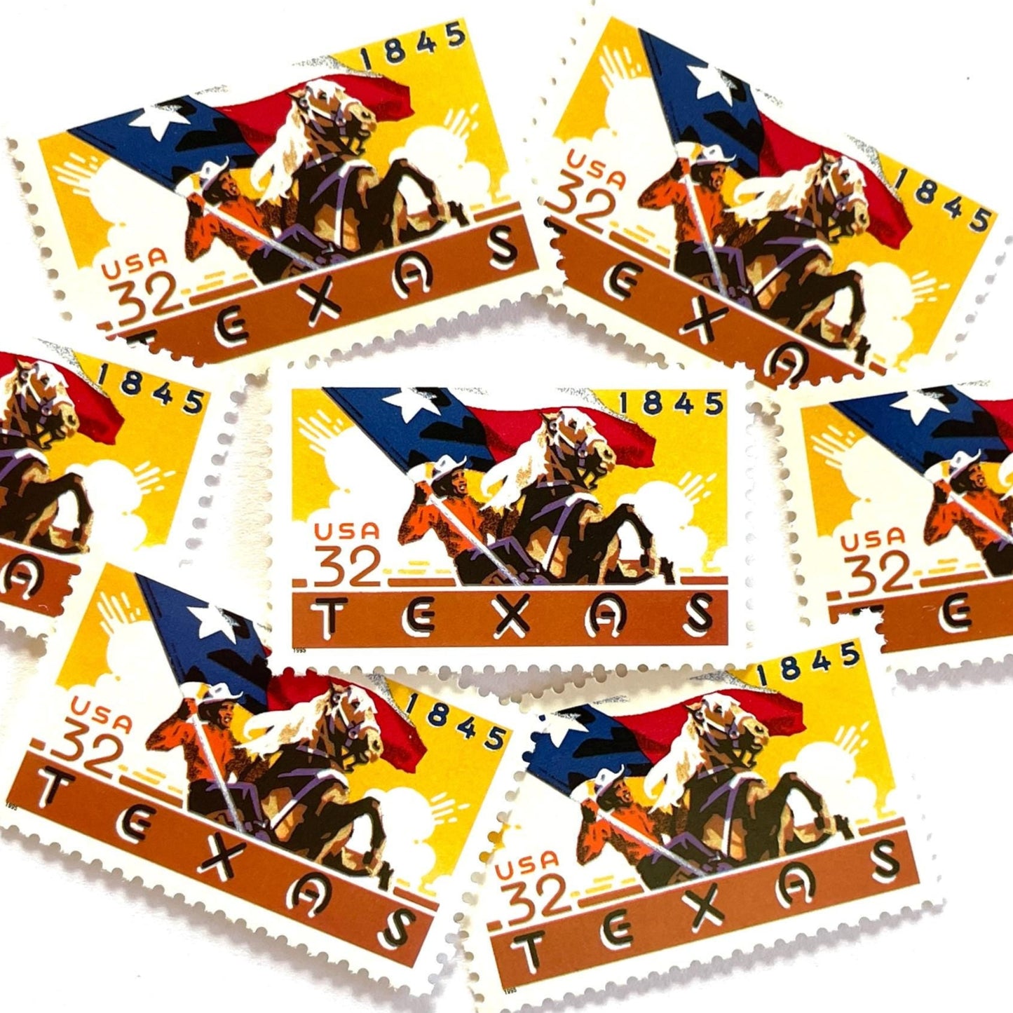 Image of Texas Statehood postage stamps from 1995, featuring a cowboy on horseback waving the Texas State flag on vintage unused 32-cent USPS postage, Scott 2968.