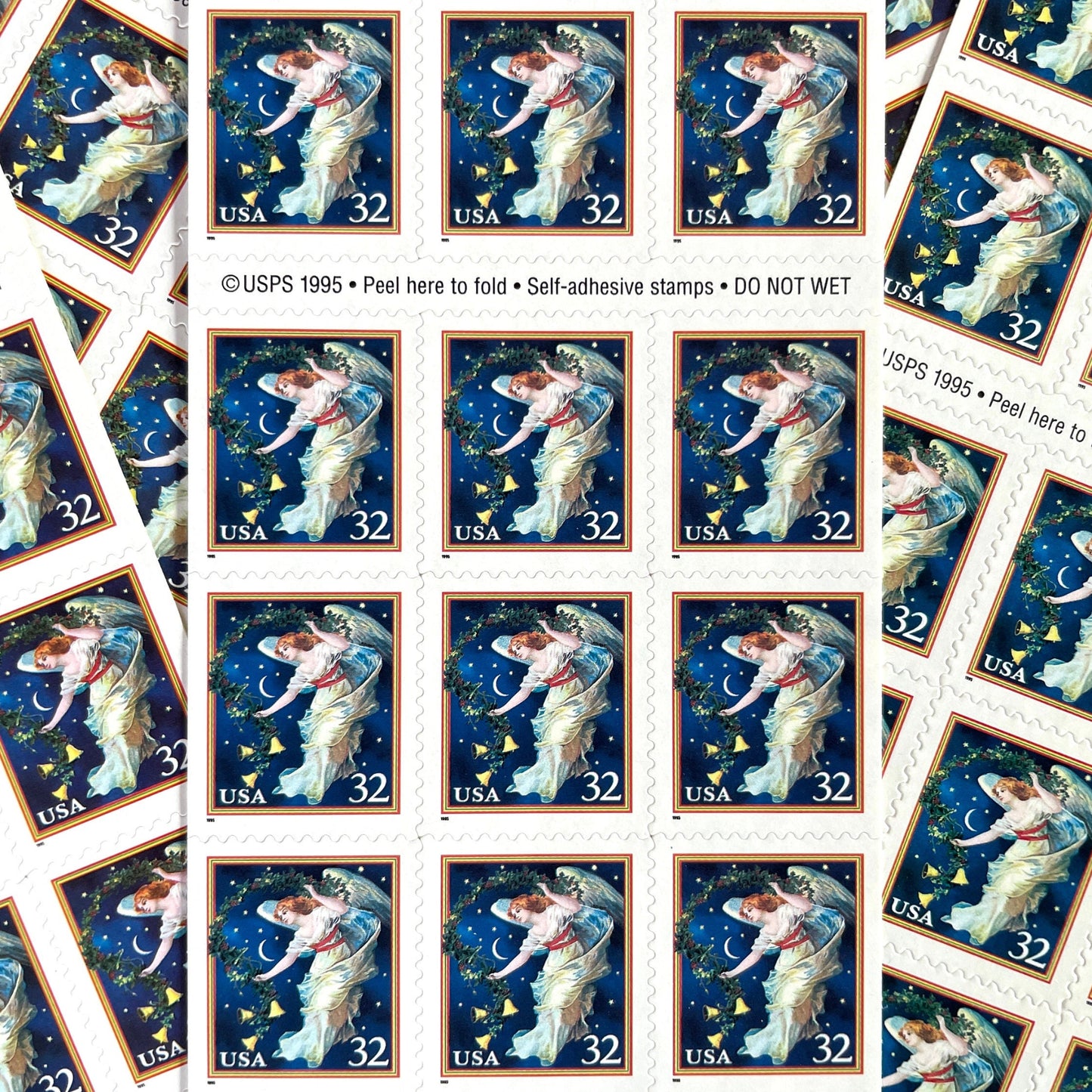Image of 1995 Christmas “Midnight Angel” 32-cent stamps. Scott #3012. Stamp Themes: Christmas, Holidays, Angel, Celestial, Heavens, Bells, Night Sky, Victorian Christmas. Blue postage stamp.