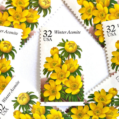 Image of vintage 1996 USPS Winter Aconite postage stamps from the Winter Garden Flowers series, featuring yellow flowers with green foliage and brown garden soil, 32-cent face value, Scott Number 3026.