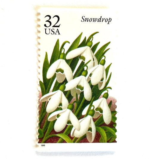Image of Snowdrop postage stamps from the Winter Garden Flowers series, featuring white winter-blooming flowers with green leaves and brown garden soil on vintage 1996 unused 32-cent USPS postage, Scott 3028.