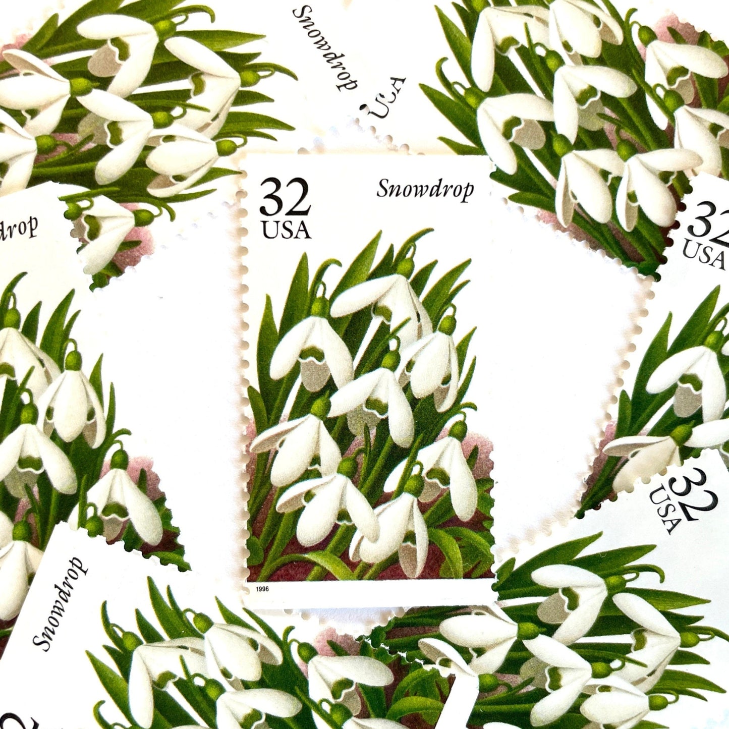 Image of Snowdrop postage stamps from the Winter Garden Flowers series, featuring white winter-blooming flowers with green leaves and brown garden soil on vintage 1996 unused 32-cent USPS postage, Scott 3028.