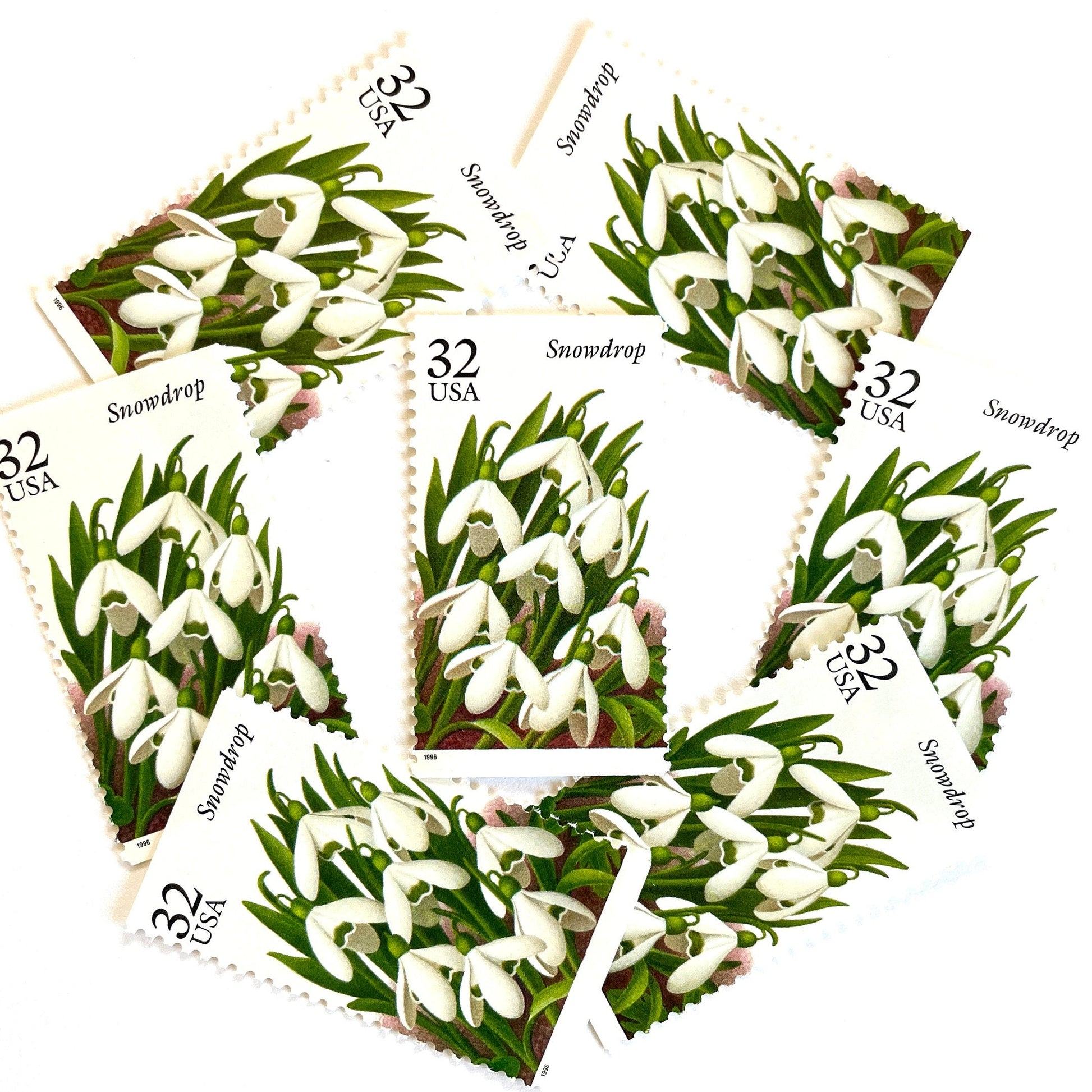 Image of Snowdrop postage stamps from the Winter Garden Flowers series, featuring white winter-blooming flowers with green leaves and brown garden soil on vintage 1996 unused 32-cent USPS postage, Scott 3028.