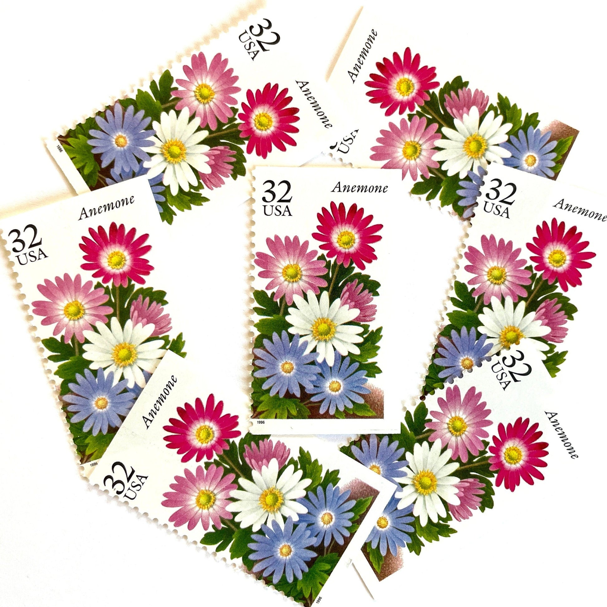 Image of Anemone postage stamps from the Winter Garden Flowers series, featuring a prink, purple, and white flowers with green foliage and garden soil on vintage unused 32-cent USPS postage, Scott Number 3029.