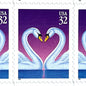 Love Swans postage stamp from 1997 featuring two white swans facing one another with their curved necks forming a heart against a purple background on vintage unused 32-cent USPS postage, Scott 3123.
