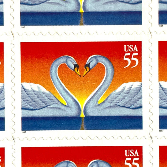 Love Swans postage stamp from 1997 featuring two white swans facing one another with their curved necks forming a heart on vintage unused 55-cent USPS postage, Scott 3124.