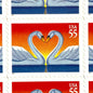 Love Swans postage stamp from 1997 featuring two white swans facing one another with their curved necks forming a heart on vintage unused 55-cent USPS postage, Scott 3124.