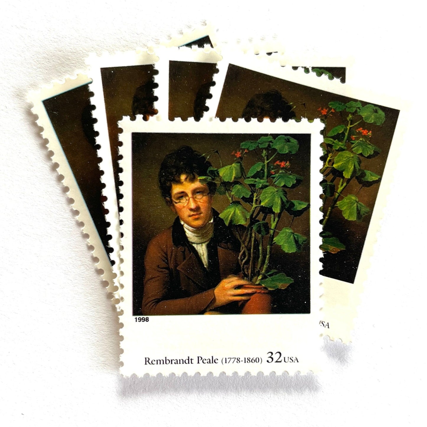 Rembrandt Peale’s "Rubens Peale with a Geranium" Postage Stamp from the 1998 Four Centuries of American Art Series. This stamp depicts a painting the artist’s brother, a botanist, holding a potted plant. An iconic horticultural or gardening theme, this predominately brown postage stamp is often used to mail wedding invitations. These are vintage unused USPS postage stamps with a face value of 32 cents each. Scott number 3236D.