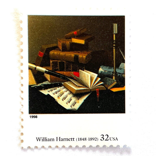 A closeup image of William Harnett’s “Music and Literature" Postage Stamp from the 1998 Four Centuries of American Art Series. This stamp depicts a still life painting of stacked books, sheet music, and a musical instrument. An iconic scholarly theme, this postage stamp is often used to mail wedding invitations. These are vintage unused USPS postage stamps with a face value of 32 cents each. Scott number 3236I.