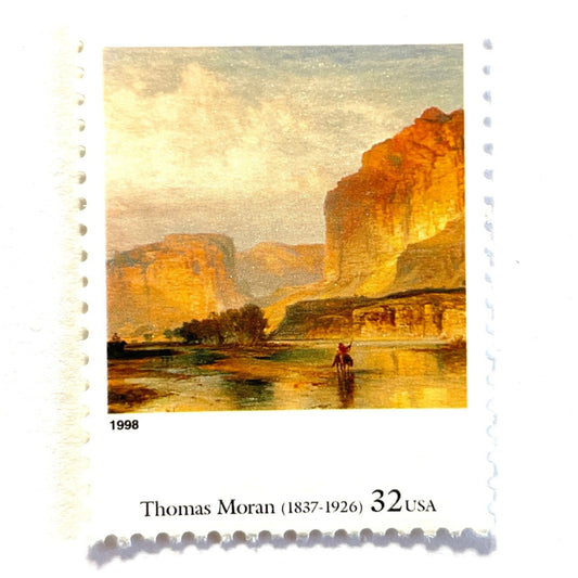 Close up image of Thomas Moran’s “Thomas Moran’s “Cliffs of Green River" Postage Stamp from the 1998 Four Centuries of American Art Series. This stamp depicts a western landscape painting of the Green River at sunset or sunrise. An iconic nature theme, this predominately beige or neutral postage stamp depicts a lone horseback rider and is often used to mail wedding invitations. These are vintage unused USPS postage stamps with a face value of 32 cents each. Scott number 3236L.