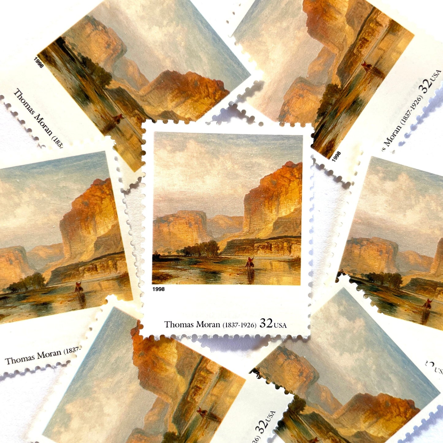 Thomas Moran’s “Cliffs of Green River" Postage Stamp from the 1998 Four Centuries of American Art Series. This stamp depicts a western landscape painting of the Green River at sunset or sunrise. An iconic nature theme, this predominately beige or neutral postage stamp depicts a lone horseback rider and is often used to mail wedding invitations. These are vintage unused USPS postage stamps with a face value of 32 cents each. Scott number 3236L.
