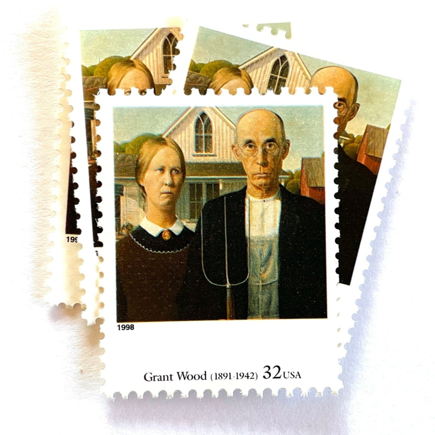 Grant Wood’s “American Gothic” Postage Stamp from the 1998 Four Centuries of American Art Series. This stamp depicts the iconic painting of man and woman, farmers or gardeners, standing in front of a farmhouse with a gothic style window. The man is holding a pitchfork. An iconic homesteading theme, this postage stamp depicts a couple and is often used for mailing wedding invitations and save the dates. These are vintage unused USPS postage stamps with a face value of 32 cents each. Scott number 3236Q.