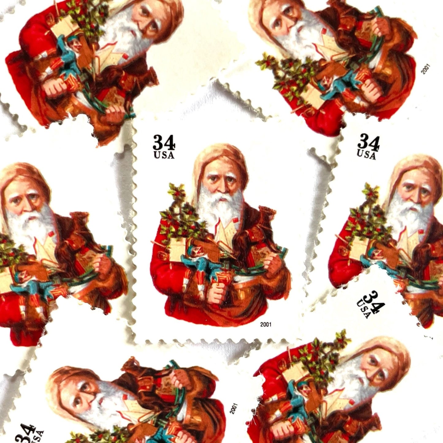 Image of 34-cent Contemporary Christmas Santa Claus Se-tenant “Santa with Toy Horse” USPS postage stamp featuring a relatively skinny white bearded Santa wearing a brown, hooded robe over a red suit. This sober looking Santa is holding a bounty of toys and gifts for children, including a doll dressed in blue and white, a small evergreen tree decorated with garland, and a rocking horse. Scott #3537. Stamp themes: Christmas, holidays, winter, Santa Claus, toys, gifts, winter wedding, winter save-the-date. Red