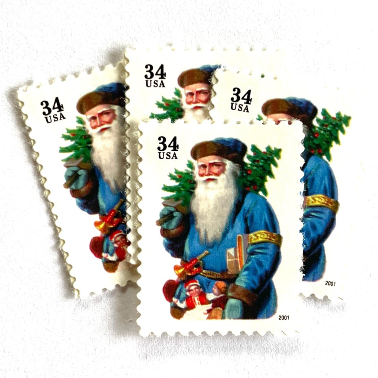 Image of 34-cent Contemporary Christmas 2001 Santa Claus Se-tenant "Santa with Horn" and blue coat USPS postage stamps featuring a relatively skinny white bearded Santa wearing a brown, hooded robe over a red suit. This jolly looking Santa is portly and jovial with a full white beard, a blue suit trimmed in gold, a blue cap, and a small horn attached to his belt. Scott #3538. Stamp themes: Christmas, holidays, winter, Santa Claus, toys, gifts, winter wedding, winter save-the-date. Blue postage stamp.