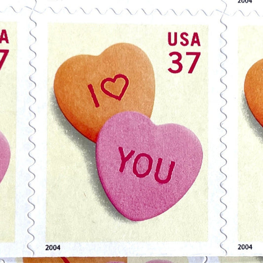 Candy Hearts postage stamp from 2004 featuring pink and yellow conversation hearts spelling I love you on vintage unused 37-cent USPS postage, Scott 3833.