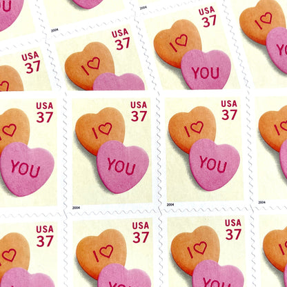 Candy Hearts postage stamps from 2004 featuring pink and yellow conversation hearts spelling I love you on vintage unused 37-cent USPS postage, Scott 3833.