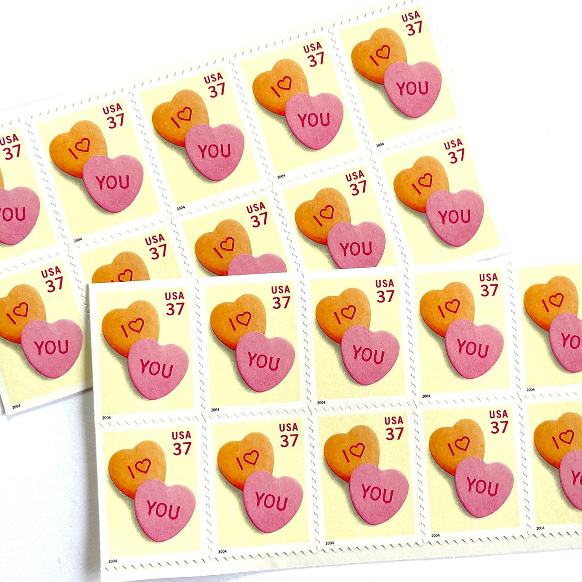 Candy Hearts postage stamps from 2004 featuring pink and yellow conversation hearts spelling I love you on vintage unused 37-cent USPS postage, Scott 3833.