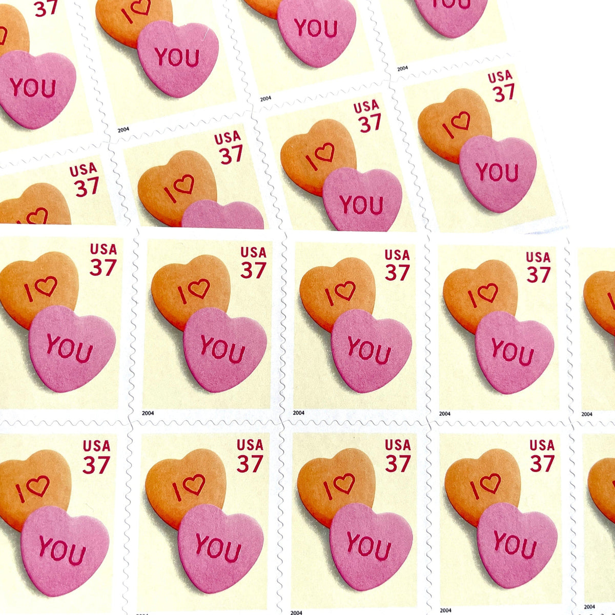 Candy Hearts postage stamps from 2004 featuring pink and yellow conversation hearts spelling I love you on vintage unused 37-cent USPS postage, Scott 3833.