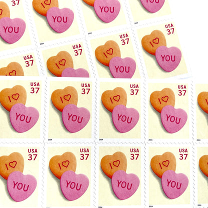 Candy Hearts postage stamps from 2004 featuring pink and yellow conversation hearts spelling I love you on vintage unused 37-cent USPS postage, Scott 3833.