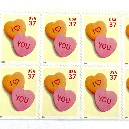 Candy Hearts postage stamps from 2004 featuring pink and yellow conversation hearts spelling I love you on vintage unused 37-cent USPS postage, Scott 3833.