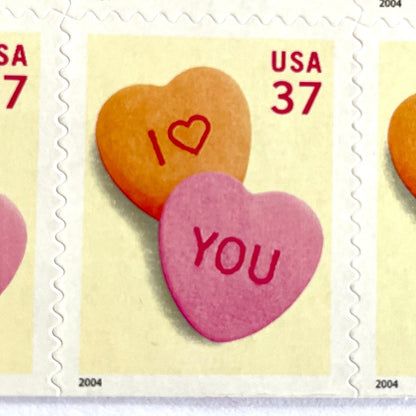Candy Hearts postage stamps from 2004 featuring pink and yellow conversation hearts spelling I love you on vintage unused 37-cent USPS postage, Scott 3833.