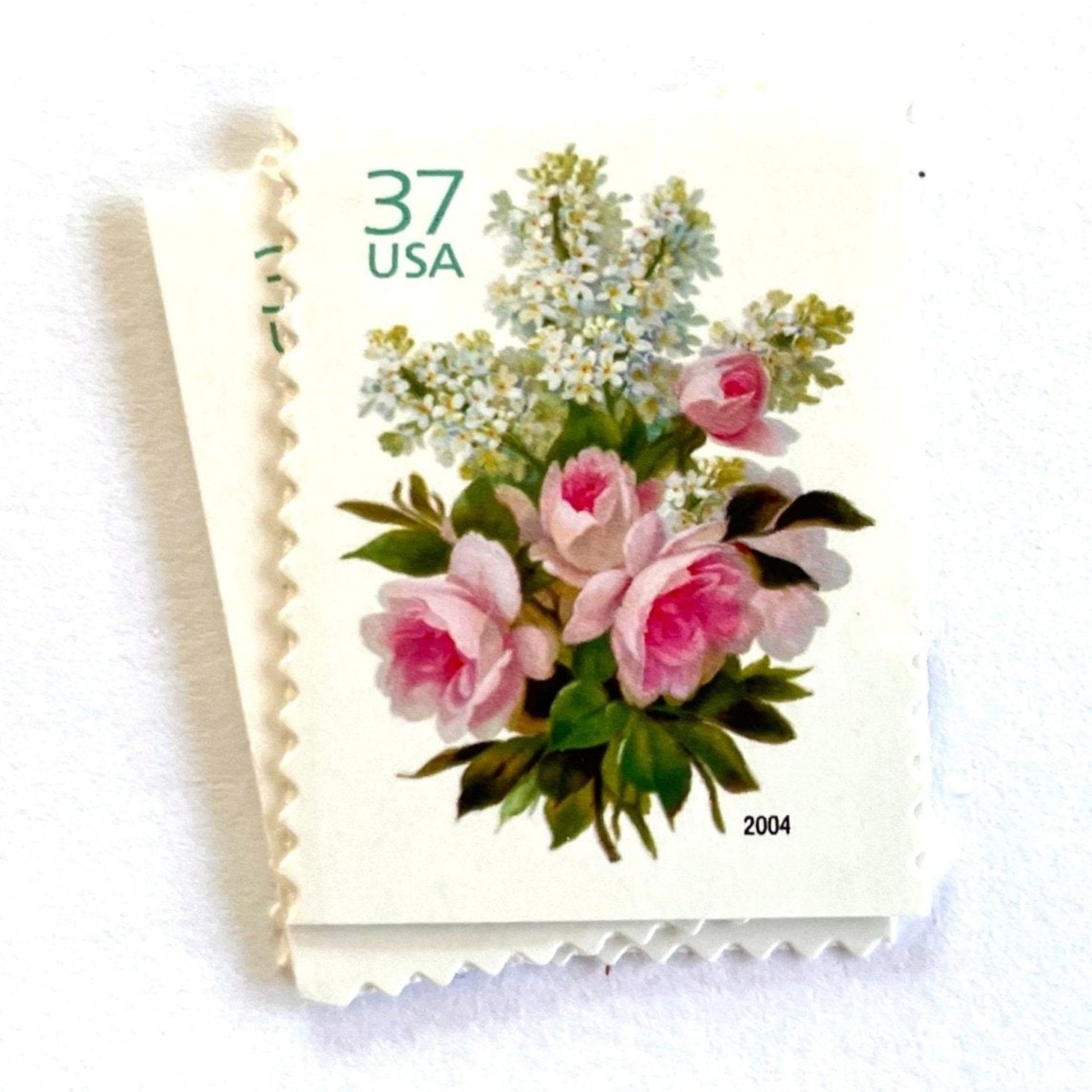 Image of 2004 Wedding Series “Garden Bouquet” unused 37-cent USPS mail stamps. Scott #3836. Stamp Themes: Flowers, Floral, Botanical, Bouquet, Wedding Bouquet, Bridal Flowers, Pastels, Victorian-era Botanical Art. Pink, White, Green, Multicolored postage stamp. Perfect postage stamp to use for save the date announcements, wedding invitation postage, shower invitations, thank you cards, valentine’s day, and snail mail.