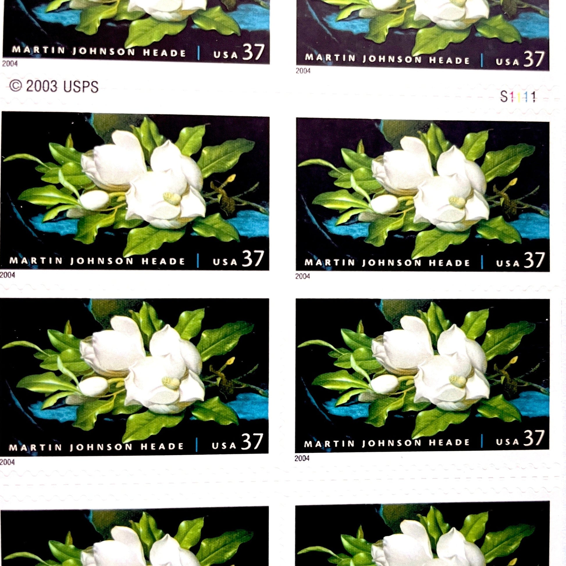 Image of 2004 American Treasures series “Martin Johnson Heade Painting” ("Giant Magnolias on a Blue Velvet Cloth”) unused 37-cent vintage USPS mail stamps. Scott #3872. Stamp Themes: Flowers, White Flowers, Floral, Botanical, Gardening, American Trees, Magnolia Tree, Magnolia Flowers. Dark Blue, Black, White, Green, Multicolored self-adhesive postage stamp. Perfect postage stamp to use for save the date announcements, wedding invitation postage, bridal shower invitations, birth announcements, thank you card