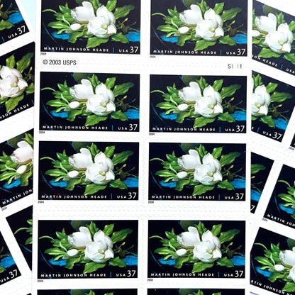 Image of 2004 American Treasures series “Martin Johnson Heade Painting” ("Giant Magnolias on a Blue Velvet Cloth”) unused 37-cent vintage USPS mail stamps. Scott #3872. Stamp Themes: Flowers, White Flowers, Floral, Botanical, Gardening, American Trees, Magnolia Tree, Magnolia Flowers. Dark Blue, Black, White, Green, Multicolored self-adhesive postage stamp. Perfect postage stamp to use for save the date announcements, wedding invitation postage, bridal shower invitations, birth announcements, thank you card