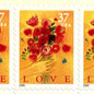 Love Bouquet postage stamp from 2005 featuring a hand offering colorful spring flowers against a yellow-gold background on vintage unused 37-cent USPS postage, Scott 3898.