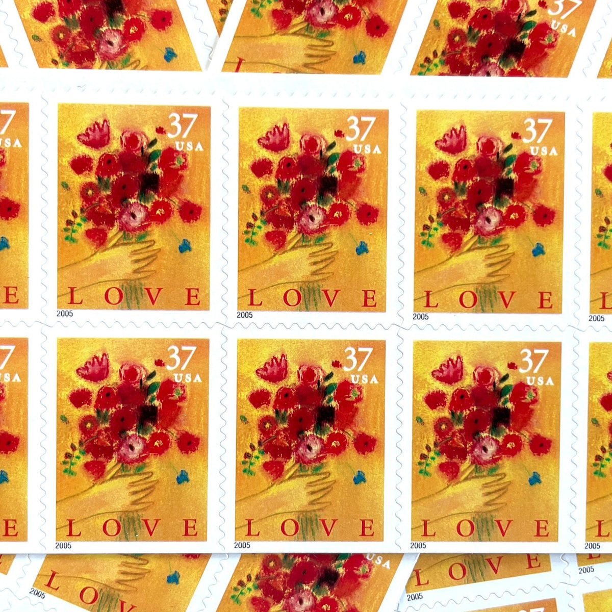 Love Bouquet postage stamps from 2005 featuring a hand offering colorful spring flowers against a yellow-gold background on vintage unused 37-cent USPS postage, Scott 3898.
