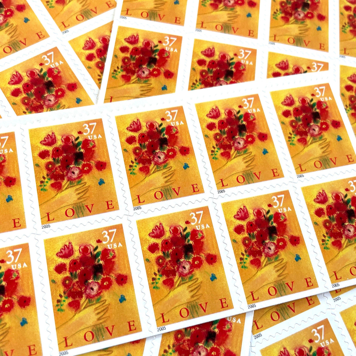 Love Bouquet postage stamps from 2005 featuring a hand offering colorful spring flowers against a yellow-gold background on vintage unused 37-cent USPS postage, Scott 3898.